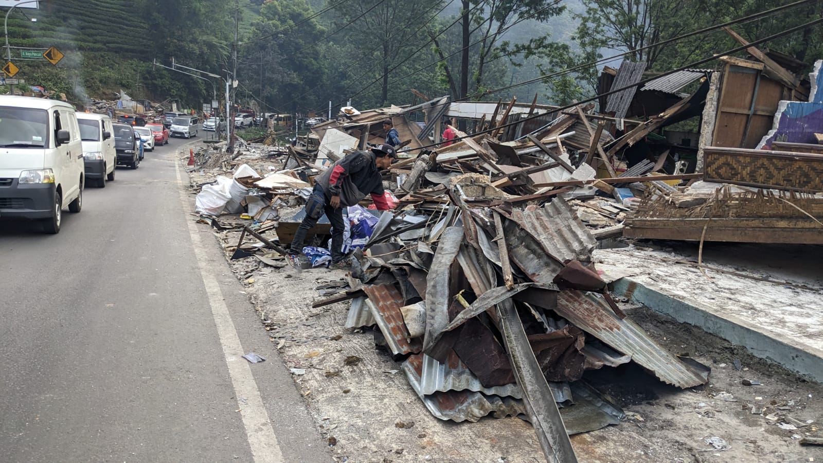 Warga mencari barang yang tersisa pasca pembongkaran lapak PKL di Kawasan Puncak, Kecamatan Cisarua, Kabuparen Bogor, Jawa Barat, Selasa (25/6/2024).