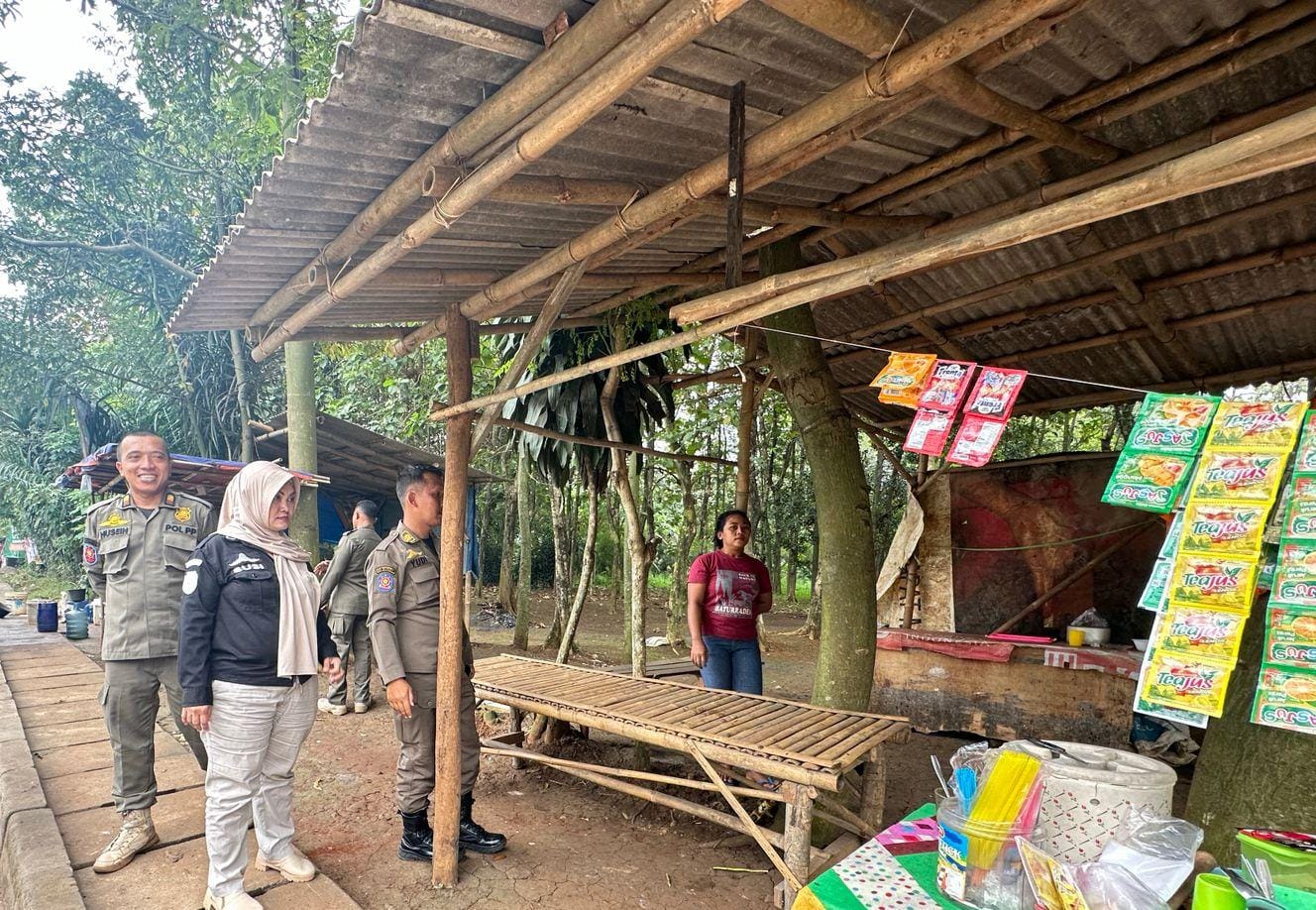 Petugas Satpol PP Kecamatan Tajurhalang, mengawasi PKL yang jualan di pinggir Jalan Raya Bomang.