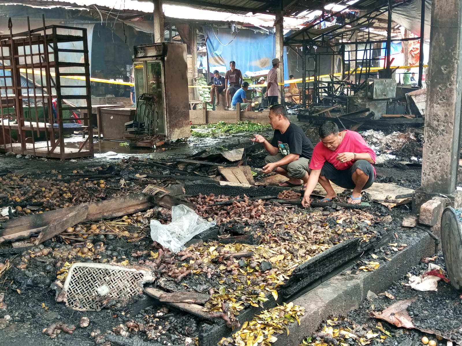 Beberapa pedagang bumbu dapur memunguti dagangannya yang masih bisa dijual Kembali pasca kebakaran Pasar Induk Kemang, Kota Bogor.