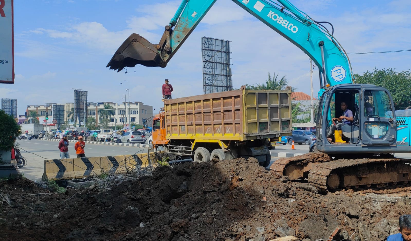 Alat berat sedang memindahkan material ke dalam truk tronton di lokasi eksekusi lahan Tol BORR Salabenda.