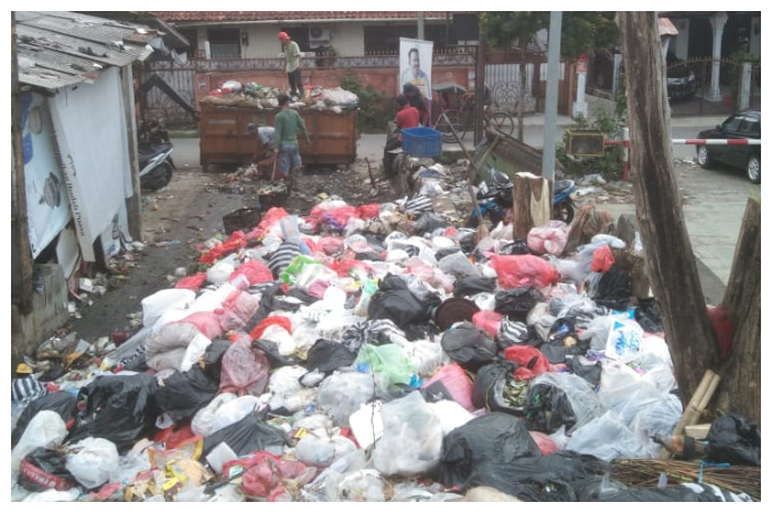 Petugas DLH Kota Bogor, sedang mengangkut sampah yang beberapa hari sering menumpuk di TPS Gang Ardio, Kelurahan Cibogor, Kecamatan Bogor Tengah.