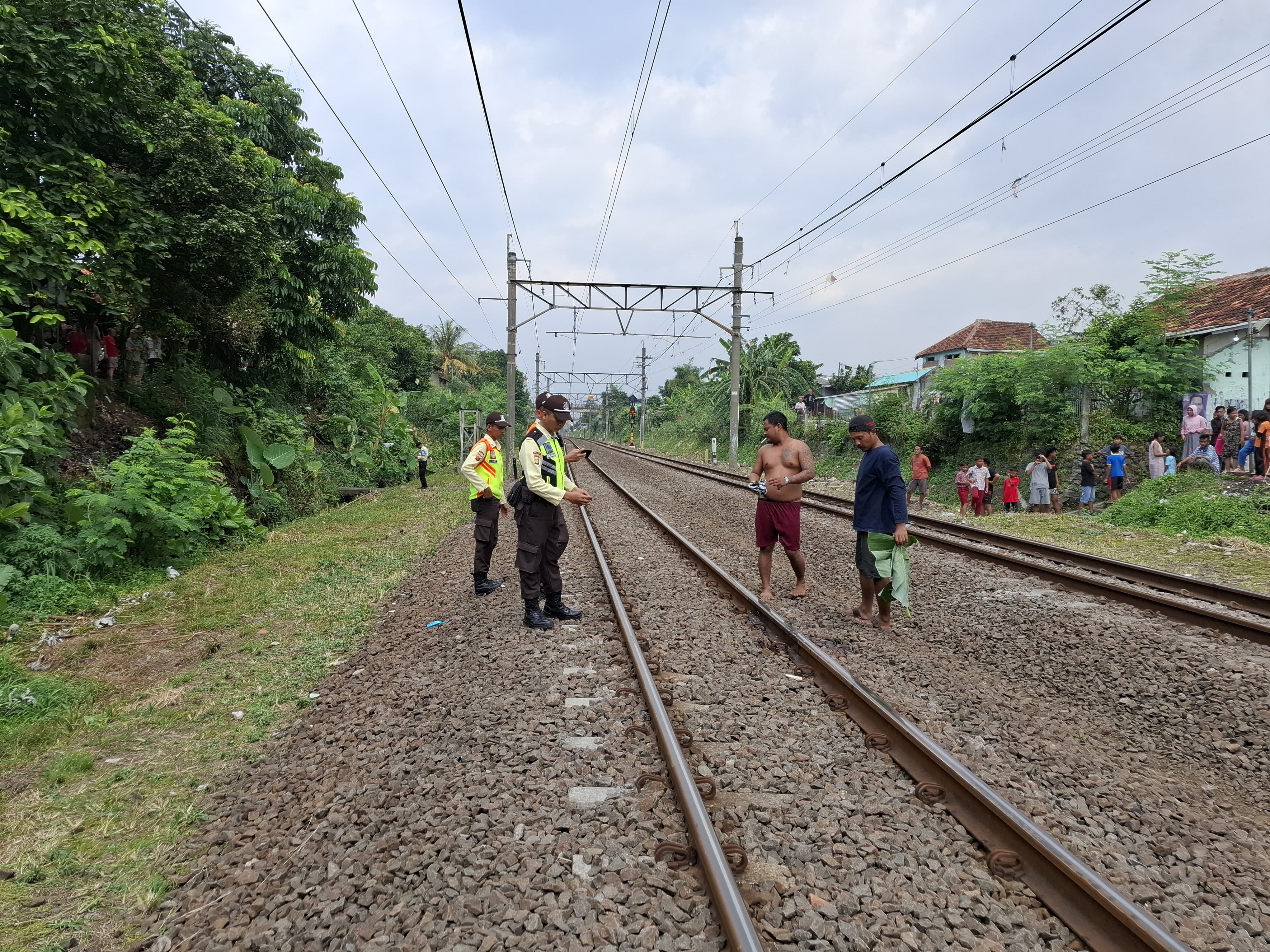 Petugas menunjukan lokasi seorang ibu tewas mengenaskan setelah tertabrak kereta di perlintasan KRL di wilayah Abesin, Kelurahan Cibogor, Kecamatan Bogor Tengah, Kota Bogor, Rabu (17/7/2024).