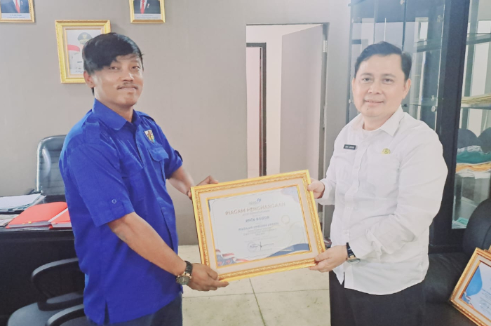 Wakil Ketua DPD KNPI Kota Bogor Beni Sitepu, saat memberikan penghargaan kepada Kepala DPPKB Kota Bogor Drs Anas S. Rasmana, M.M.