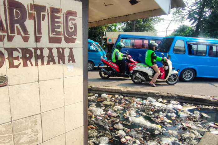 Bangunan bekas warteg di jalan utama Parung yang dipenuhi sampah dan genangan air berwarna hitam.