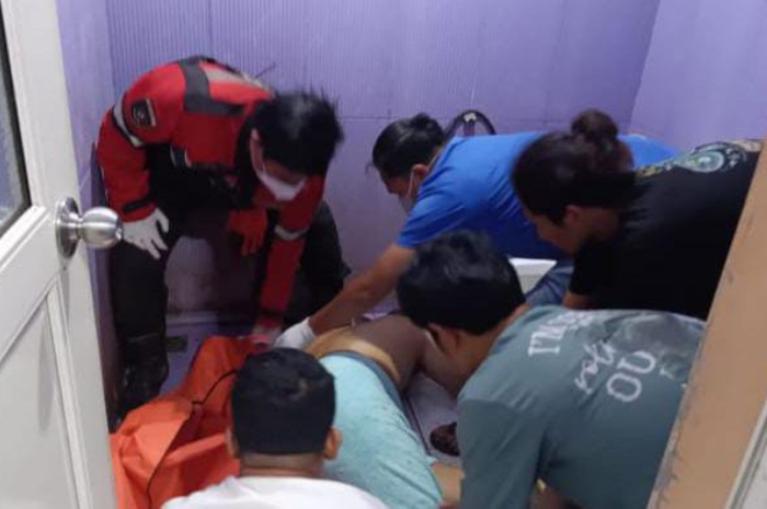 Petugas Polsek Gunung Putri ketika mengevakuasi jasad karyawan pabrik bakso yang tewas di dalam kamar mandi mes tempatnya bekerja, Selasa (6/8/2024).