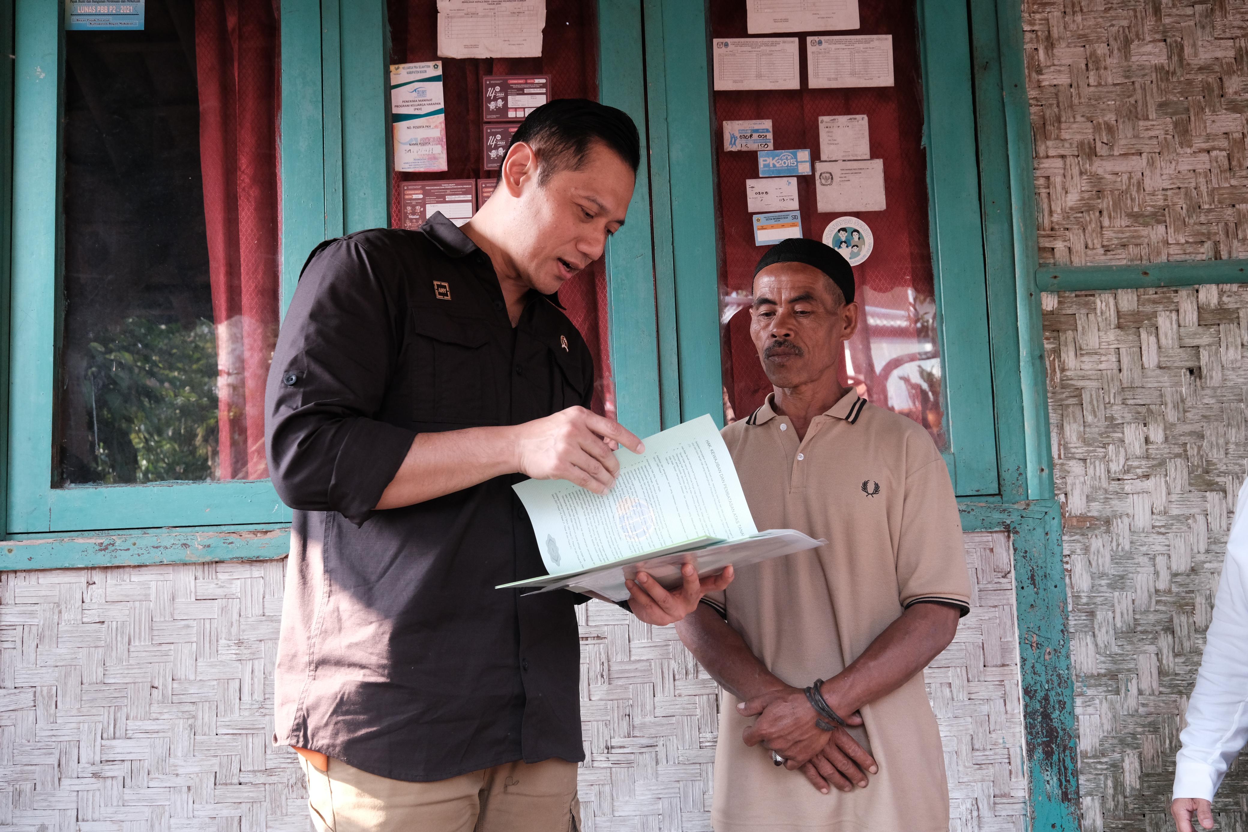 Menteri ATR/BPN Agus Harimurti Yudhoyono menyerahkan sertifikat PTSL ke warga Desa Cibalung, Cijeruk, Kabupaten Bogor.