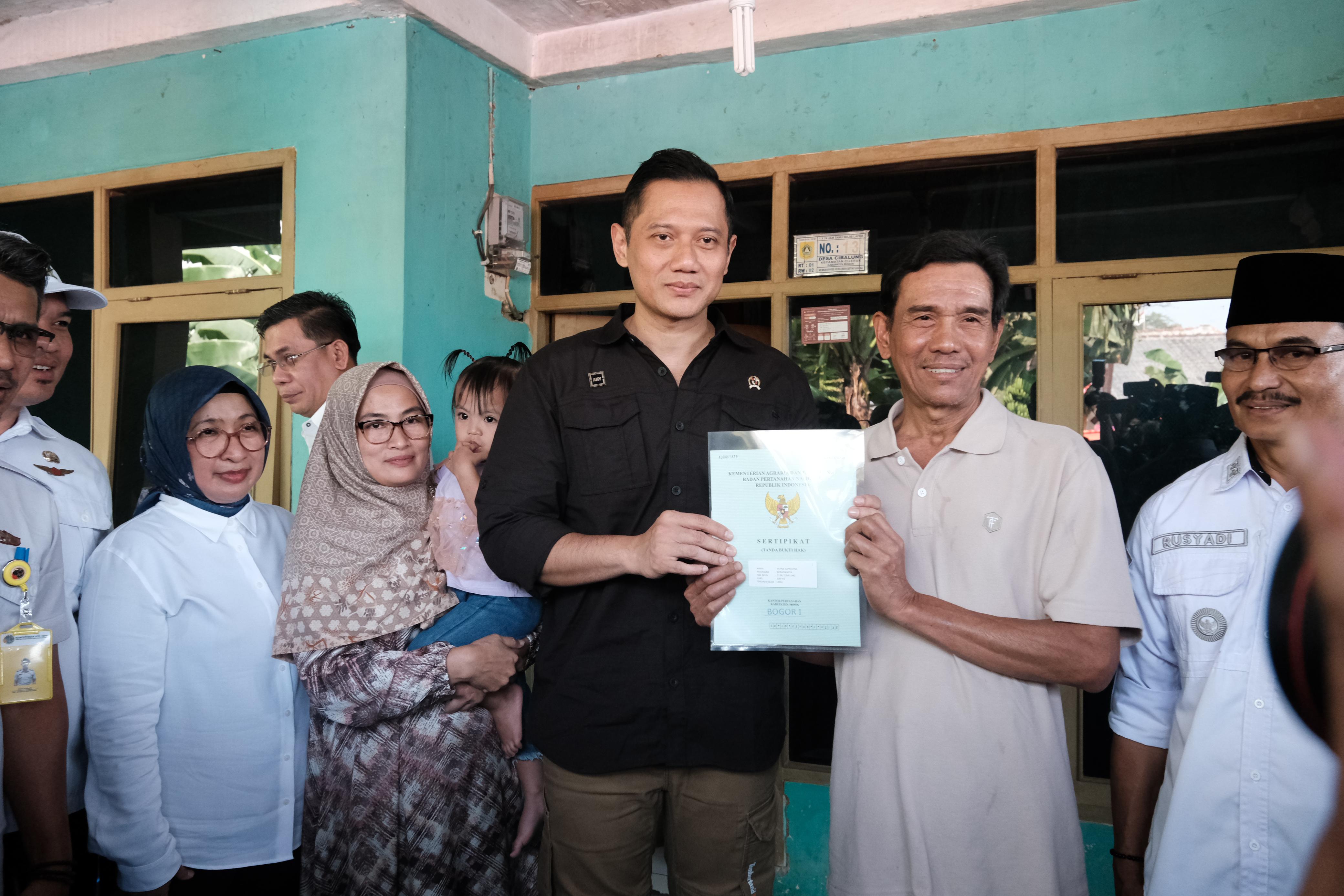 Menteri ATR/BPN Agus Harimurti Yudhoyono menyerahkan sertifikat PTSL ke warga Desa Cibalung, Cijeruk, Kabupaten Bogor.