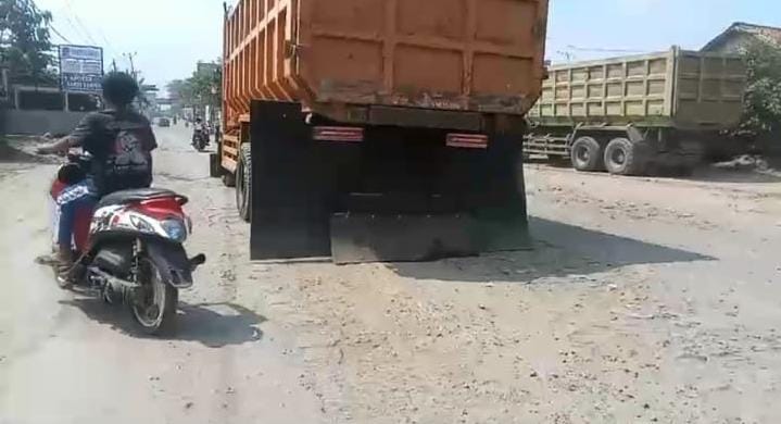 Aksi remaja mengendarai sepeda motor tanpa helm saat menyalip truk tambang di Parung Panjang.