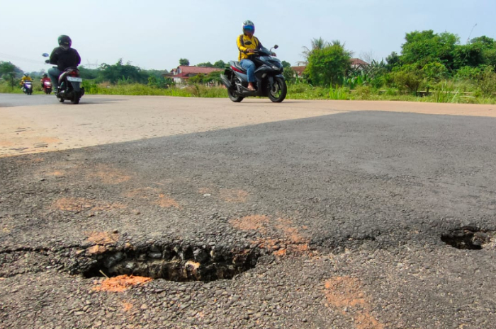 Salah satu ruas Jalan Bomang yang kembali ambles dan retak. Padahal belum lama diperbaiki.