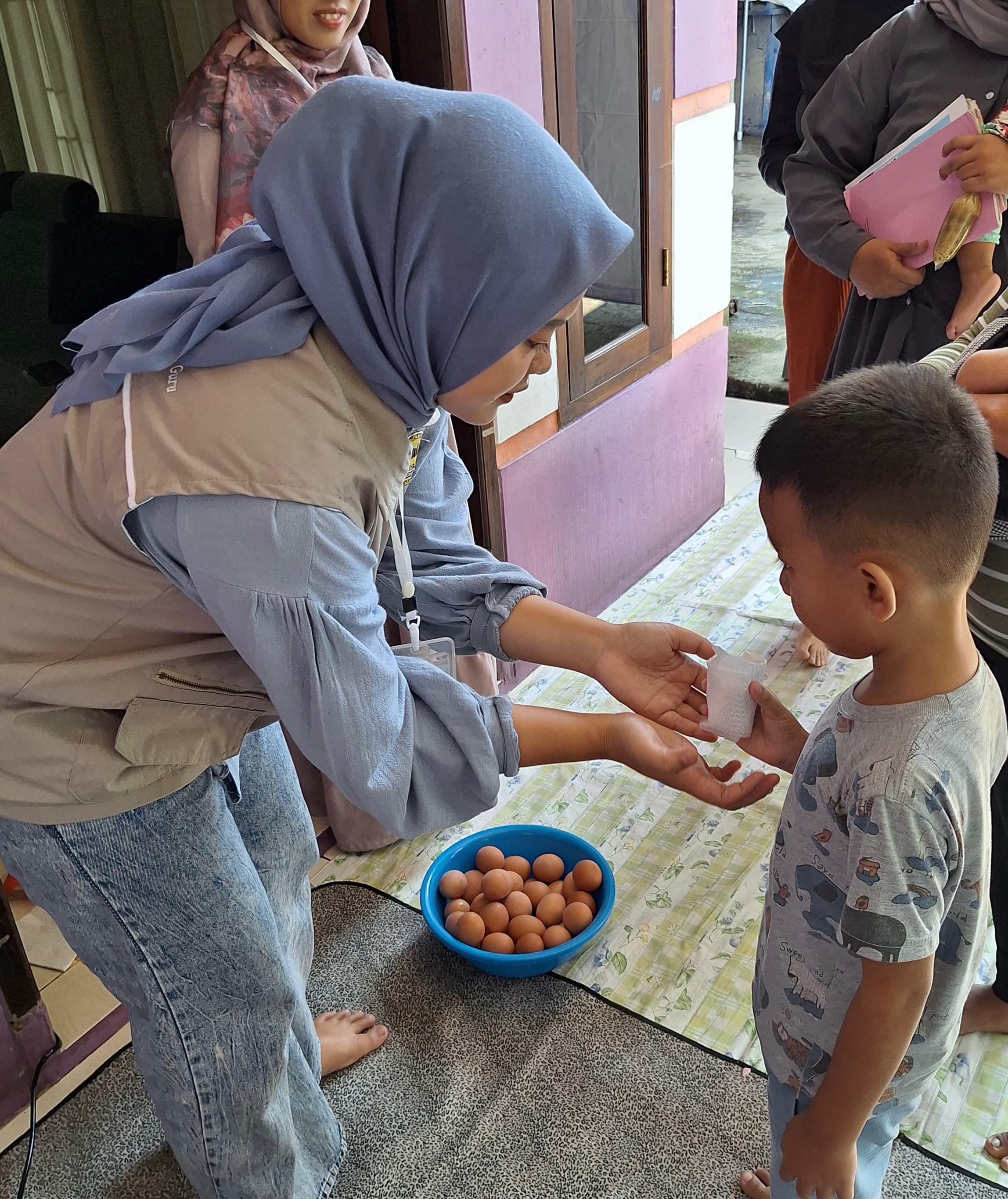 Mahasiswa UNIDA Bogor membagikan puluhan butir telur kepada anak-anak Posyandu Flamboyan di Desa dan Kecamatan Cigombong.