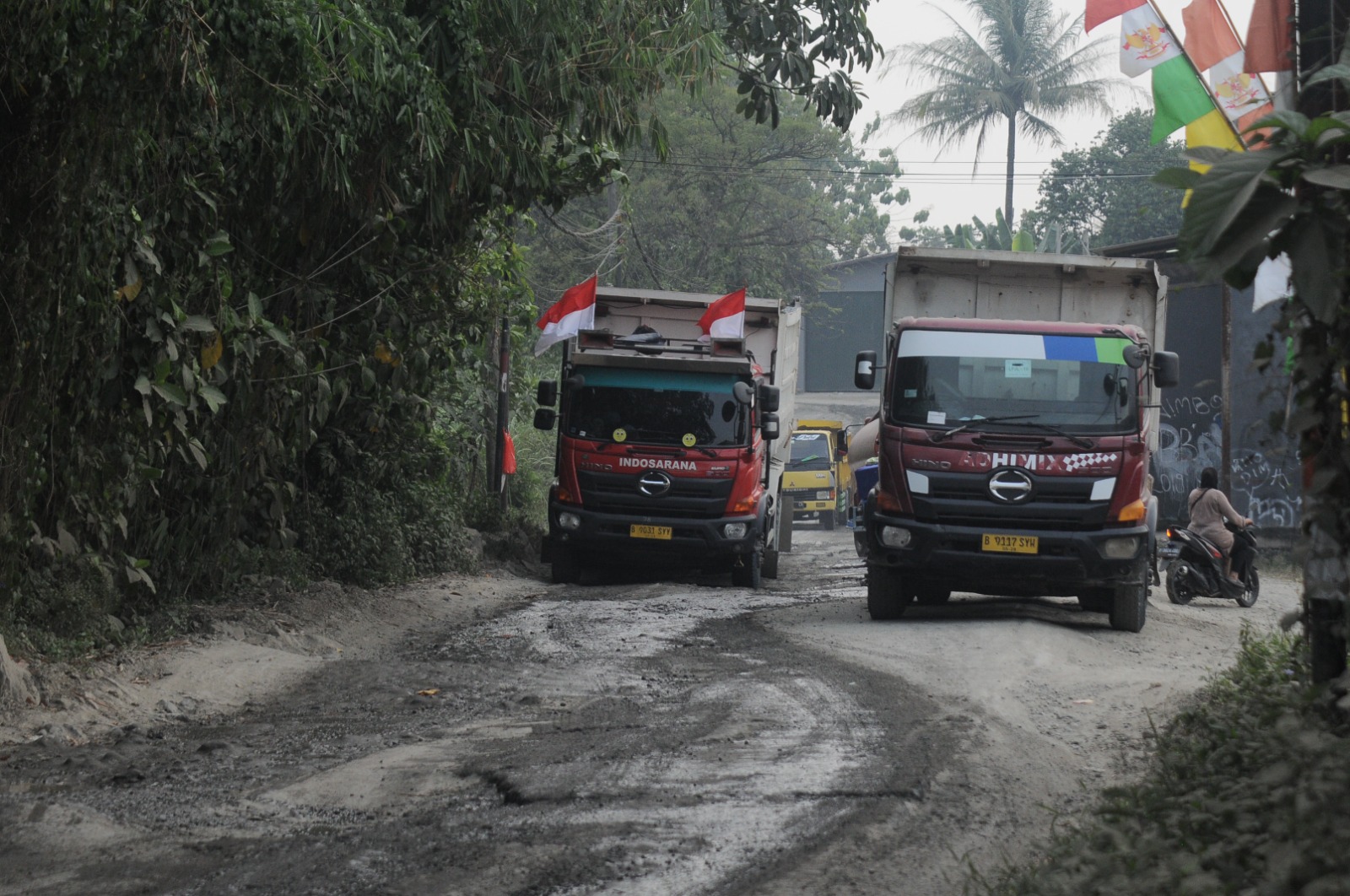 Sejumlah truk tambang melintas di jalan rusak yang ada di Kecamatan Parung Panjang, Kabupaten Bogor, Kamis (15/8/2024). Kondisi jalan rusak akibat tonase kendaraan truk melibisi kapasitas.