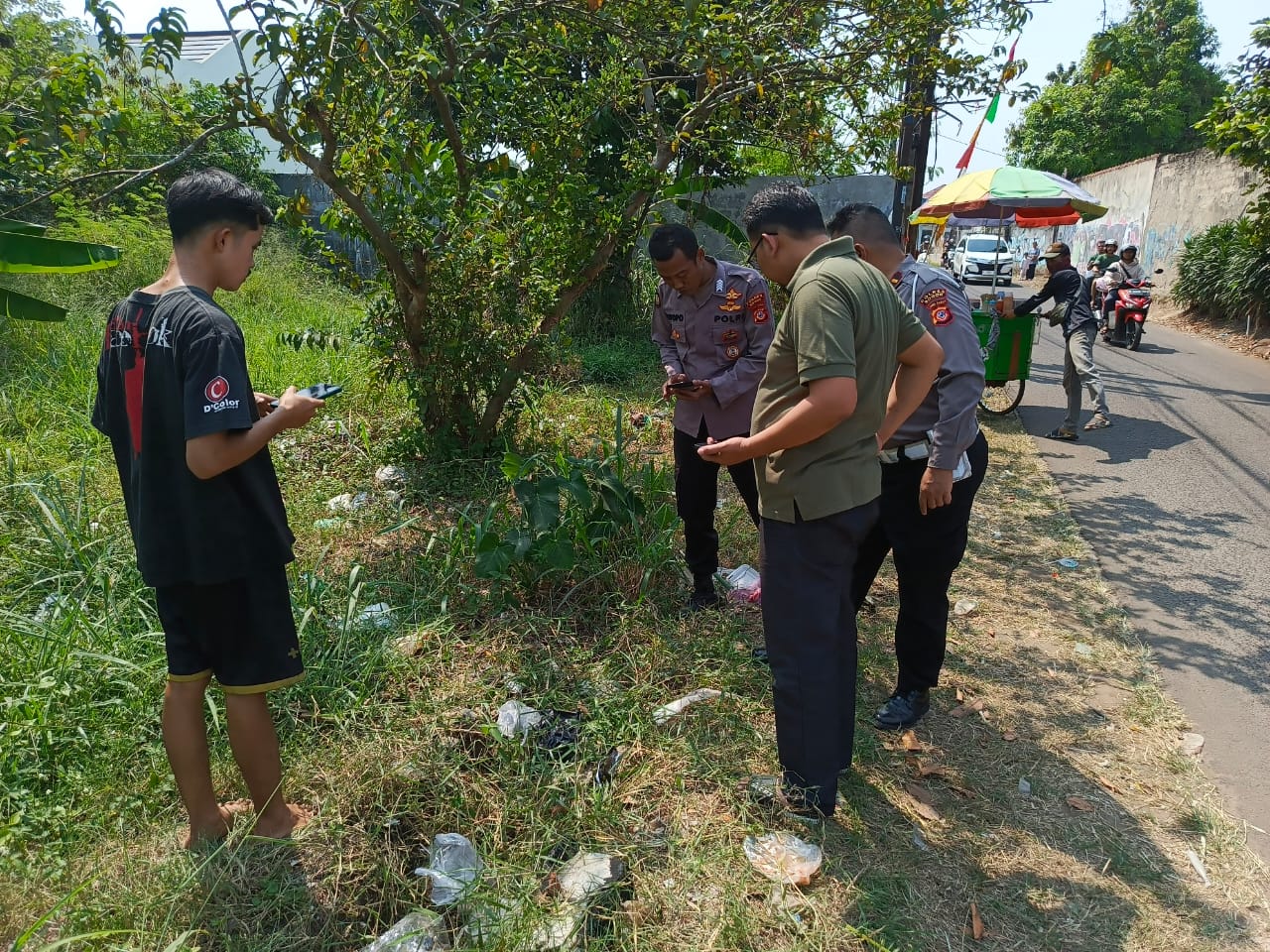 Petugas Polsek Parung, Polres Bogor, mengecek lokasi ditemukannya bayi oleh warga.