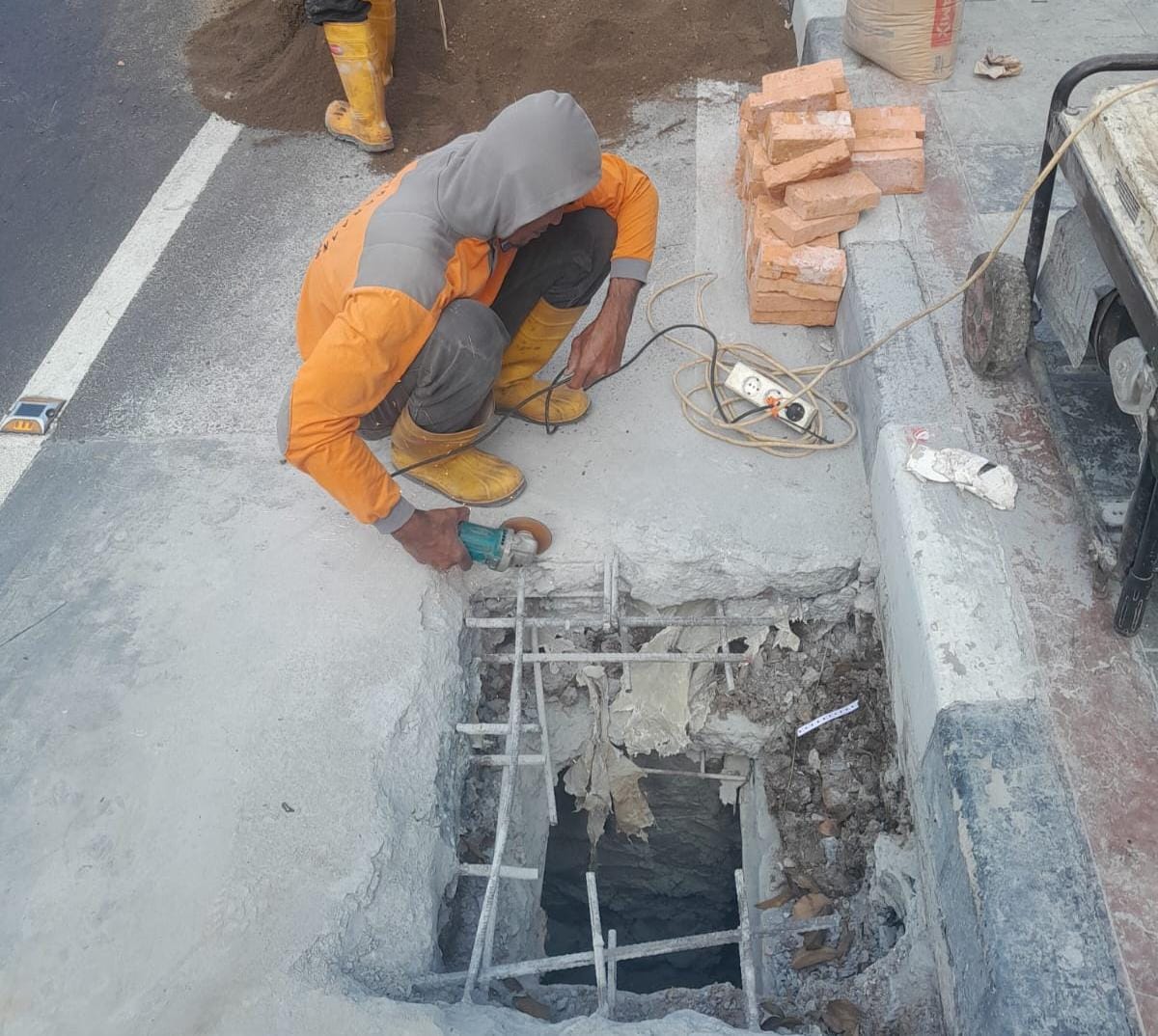 Petugas PUPR memperbaiki lubang yang ada di Jalan Otto Iskandardinata, Kota Bogor.