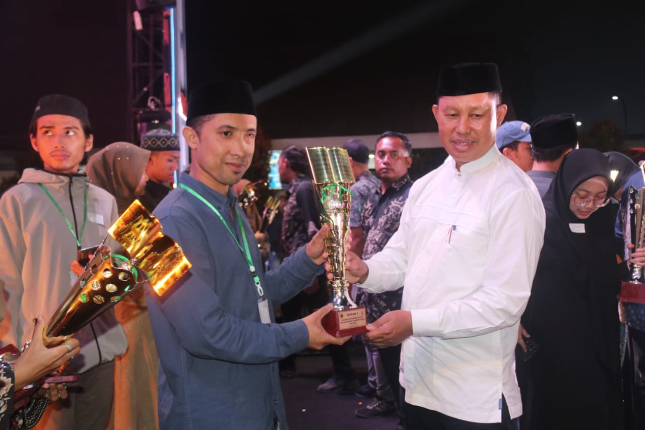 Pj Bupati Bogor, Asmawa Tosepu saat menyerahkan piala kepada pemenang lomba MTQ tingkat Kabupaten Bogor tahun 2024.