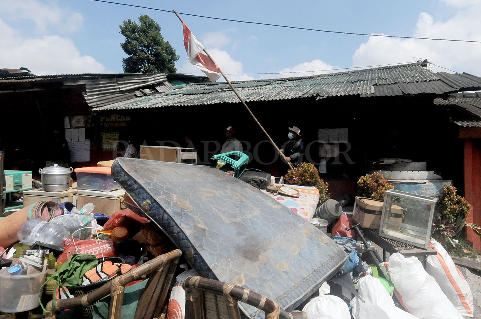 Warga menurunkan tiang Bendera Merah Putih saat dilakukan pembongkaran bangunan. Foto :