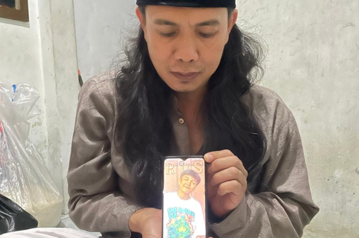 Orang tua Moh. Ridwan (16) saat menunjukan foto anaknya yang menjadi korban penganiayaan hingga meninggal dunia.