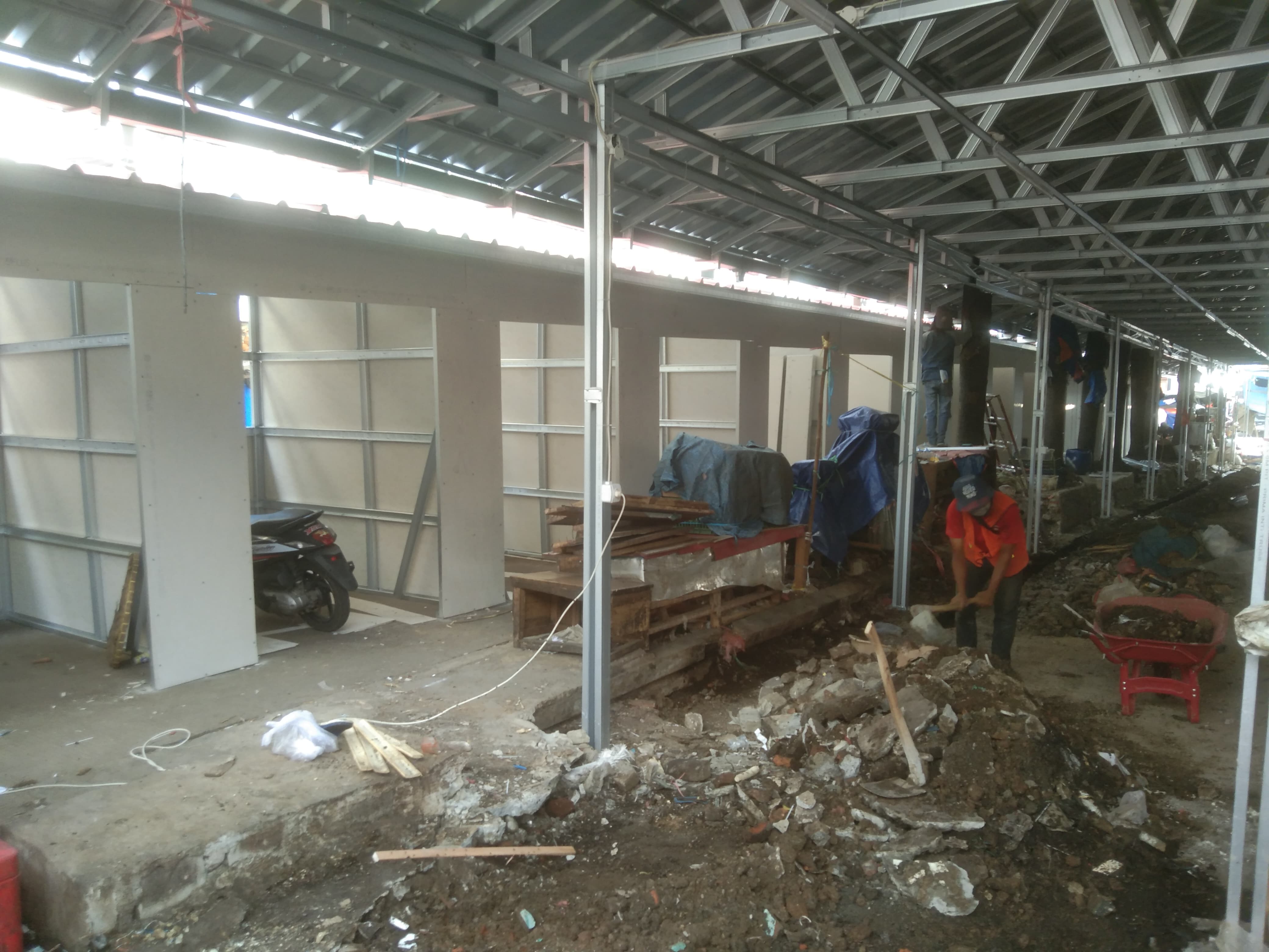 Pekerja sedang melakukan pekerjaan membuat  kios kios tempat penampungan sementara (TPS)  untuk para pedagang terdampak Revitalisasi Pasar Merdeka kota bogor, Jumat (20/9/2024) .