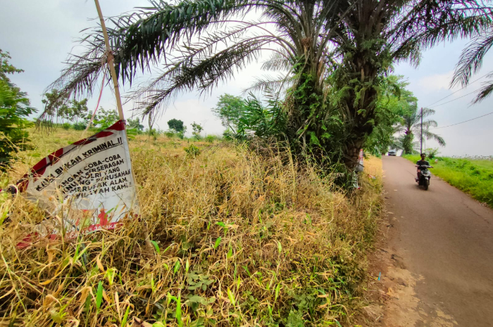 Spanduk penolakan di dekat lahan konflik agraria di Desa Iwul, Parung Bogor.