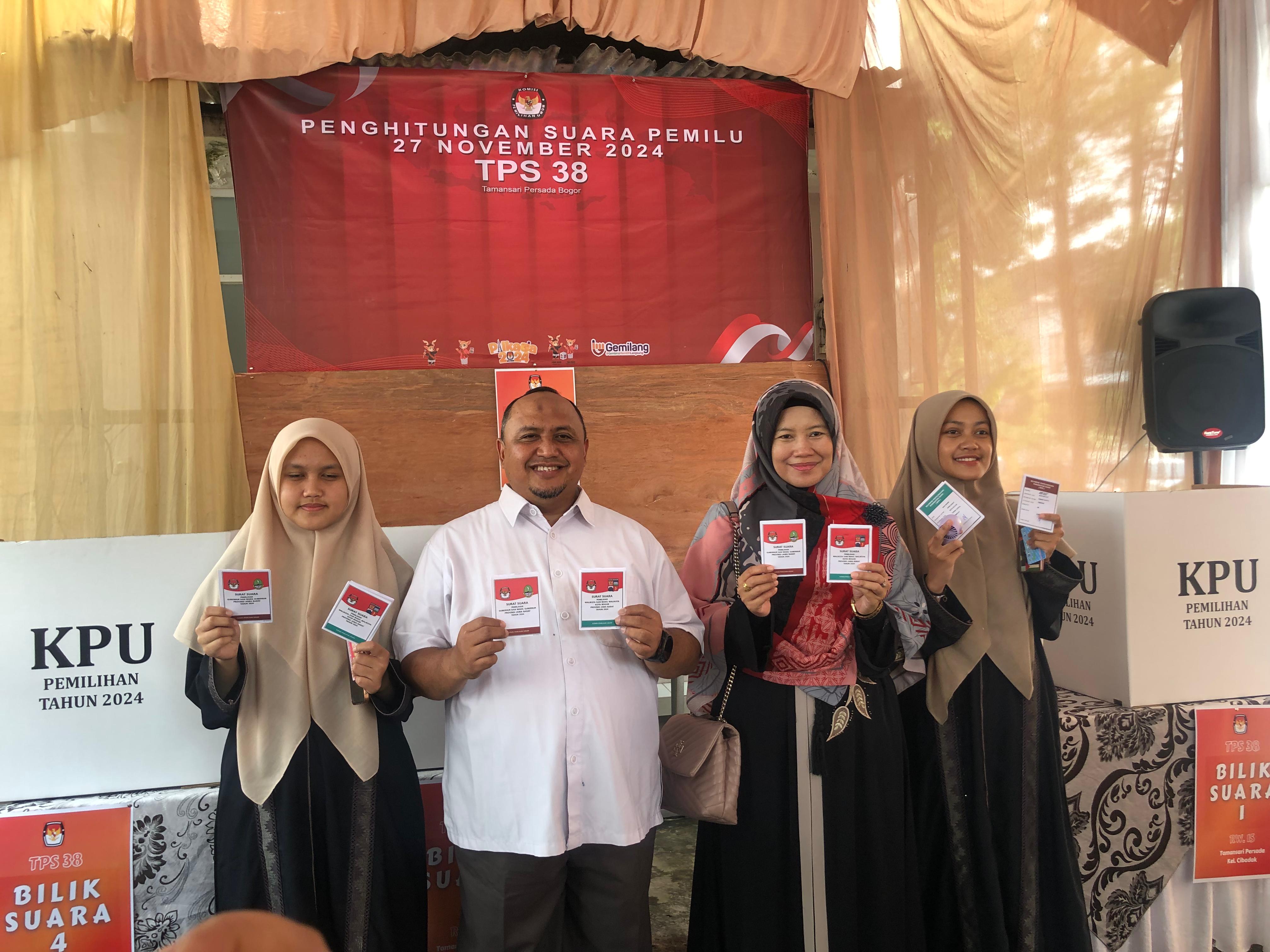 Calon Wali Kota Bogor, Atang Trisnanto bersama keluarga saat melakukan pencoblosan di TPS 38, Taman Sari Persada.