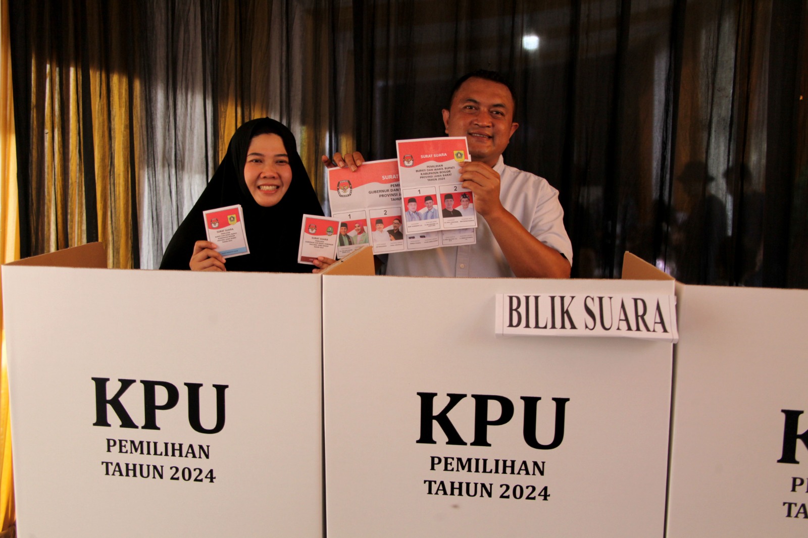 Calon Bupati nomor urut 01, Rudy Susmanto didampingi Isteri, Eva Marthiana usai gunakan hak pilihnya di TPS 003, Pakansari, Kabupaten Bogor, Rabu (27/11/2024).