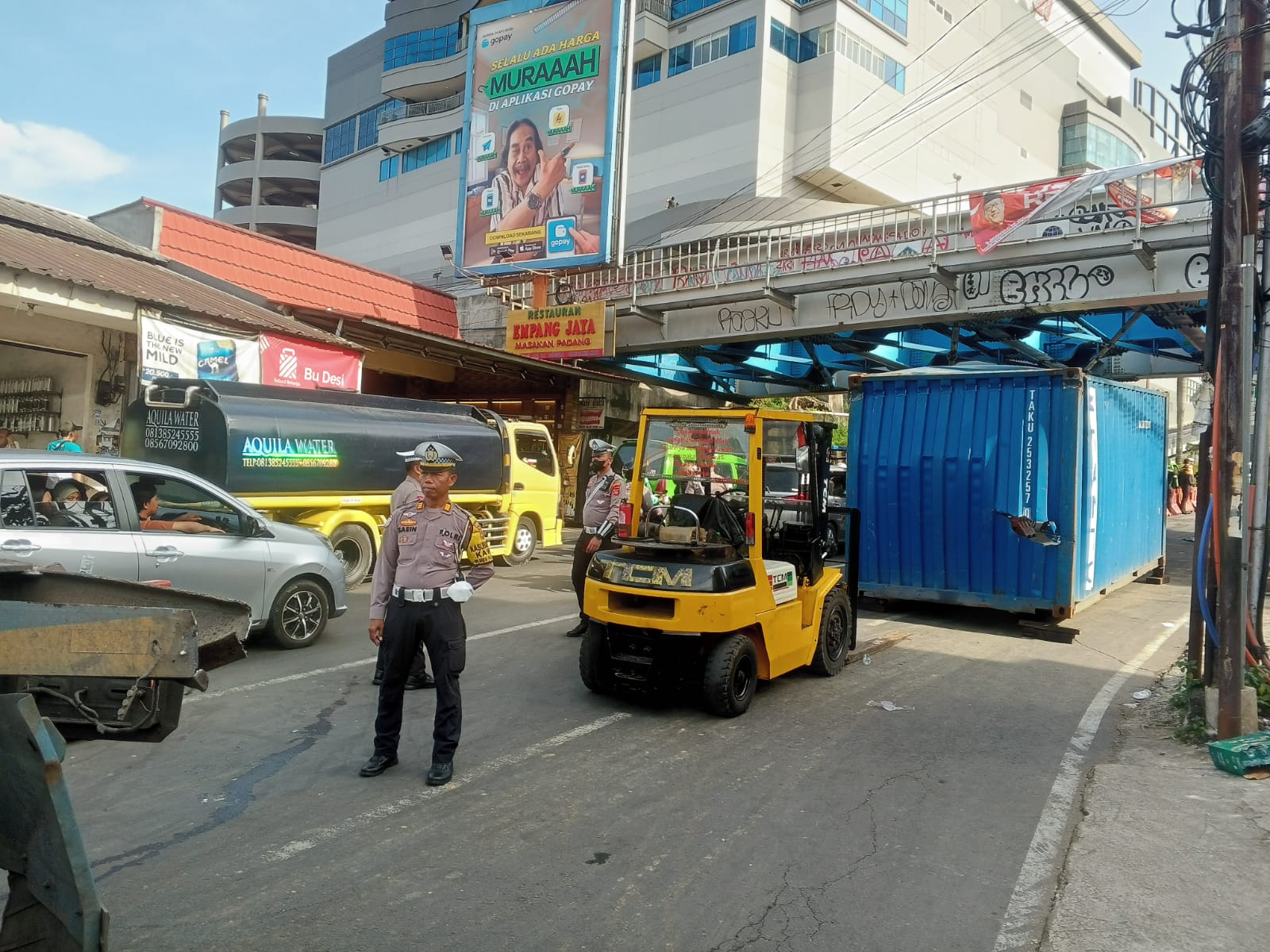 Proses evakuasi truk kontener yang tersangkut di talang rel kereta api samping Mall BTM Bogor.
