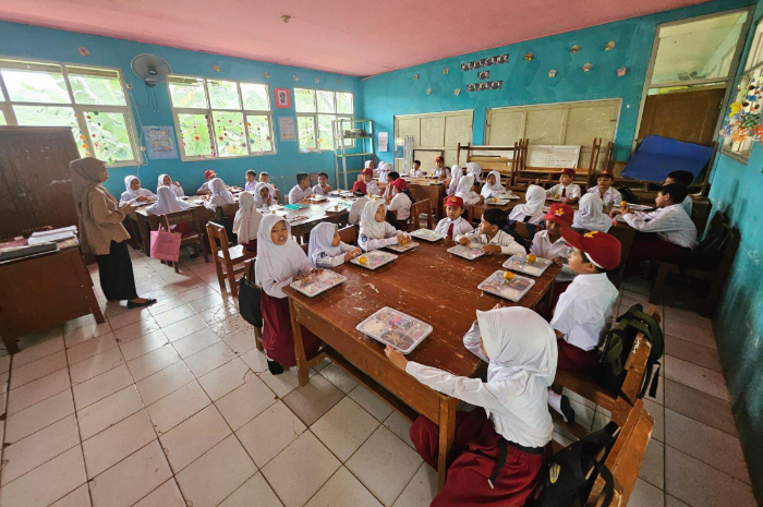 Para siswa SDN Karang Tengah 04 tengah menyantap paket makan bergizi gratis.