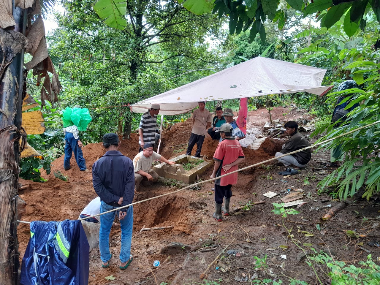 Warga Kampung Cicadas, Kabupaten Sukabumi saat memindahkan makam tua akibat pergeseran tanah.