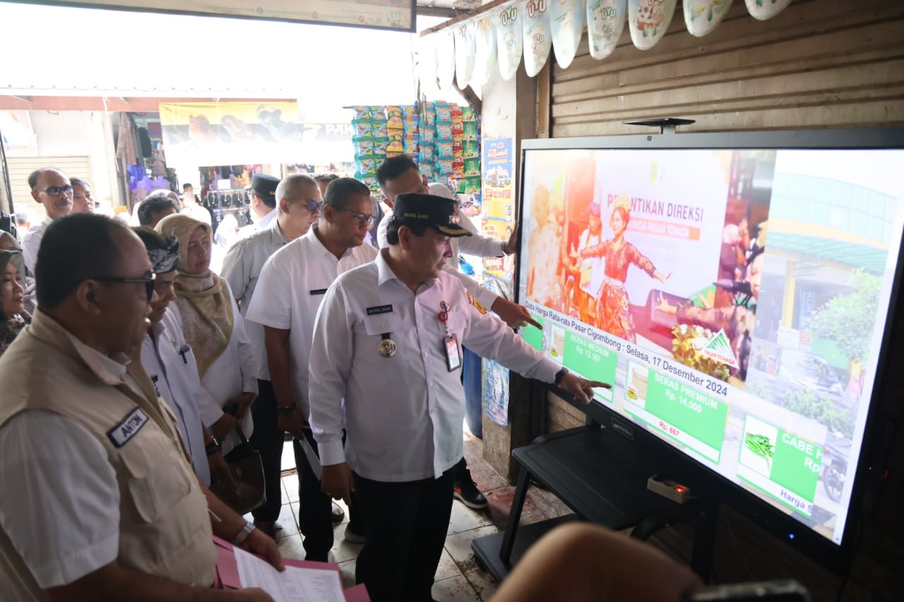 Pj Bupati Bogor saat melihat layar informasi harga komoditas di Pasar Cigombong.
