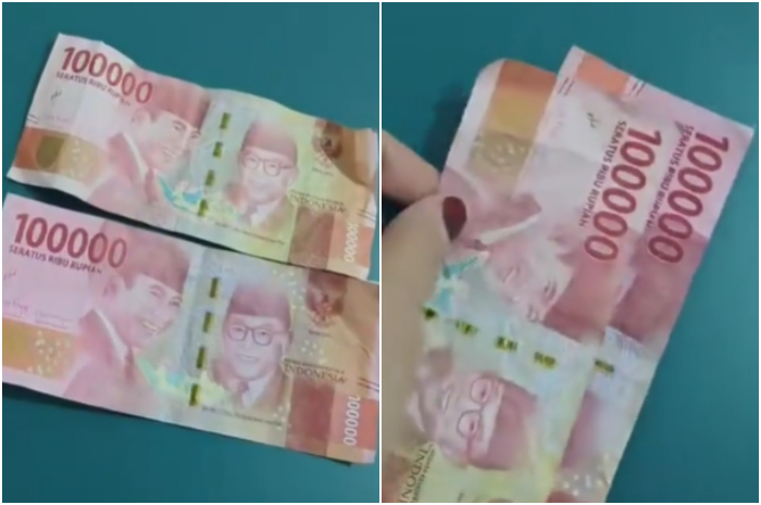 Seorang wanita memperlihatkan uang palsu dan uang asli.