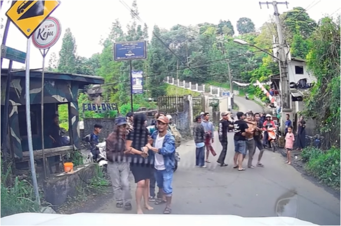 Seorang wanita saat terlibat percekcokan dan dilerai warga sekitar di jalur alternatif Puncak Bogor.