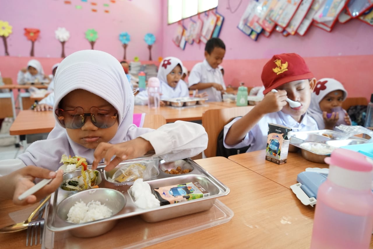 Sejumlah siswa menikmati makanan  saat  kegiatan uji coba makan bergizi gratis di SDN Bubulak 2, Kota Bogor.