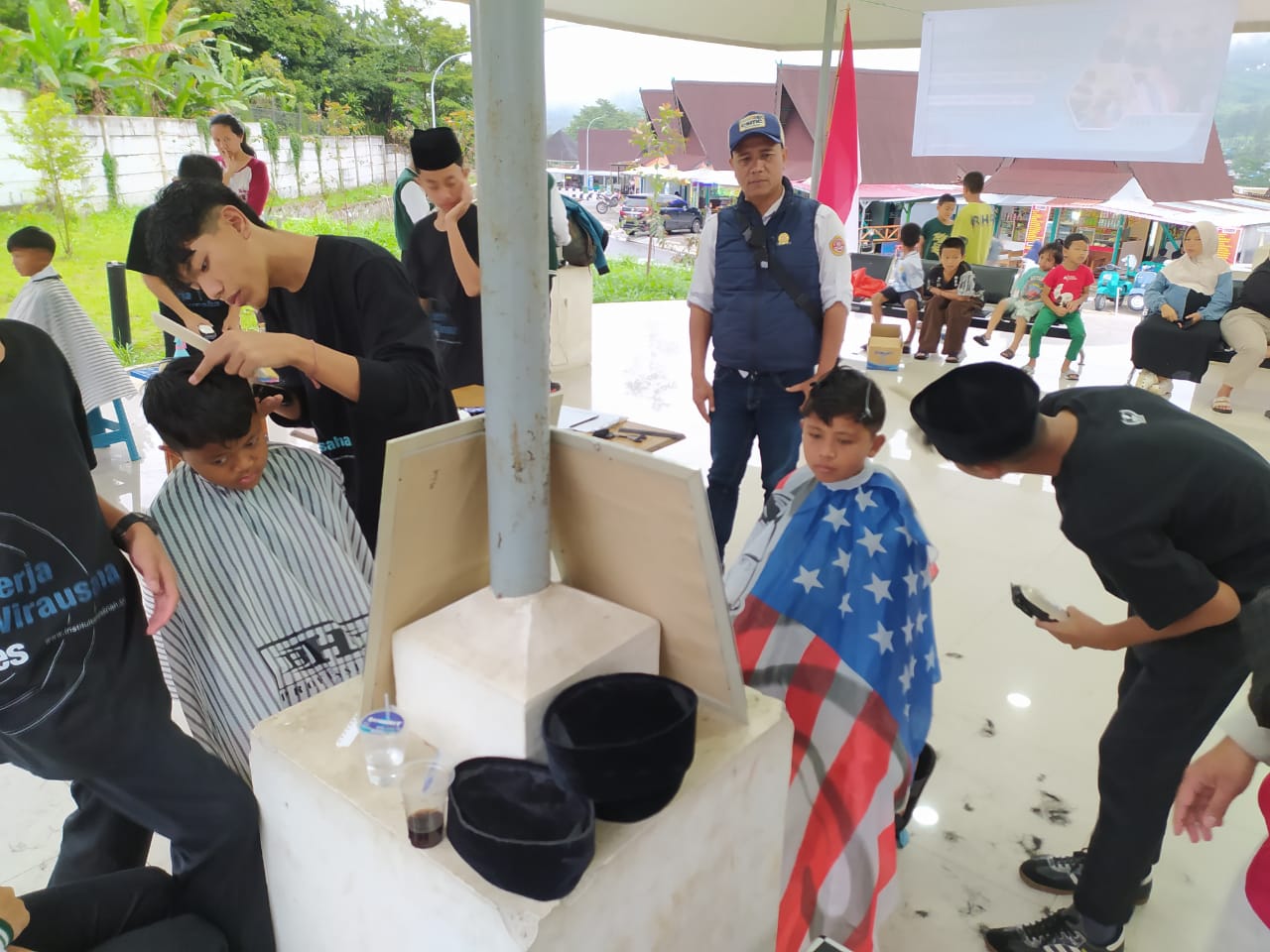 Puluhan warga antusias mengikuti pangkas rambut gratis di Rest Area Gunung Mas Puncak Bogor. Pemangkas rambut atau barber merupakan para santri yang telah dilatih oleh profesional.