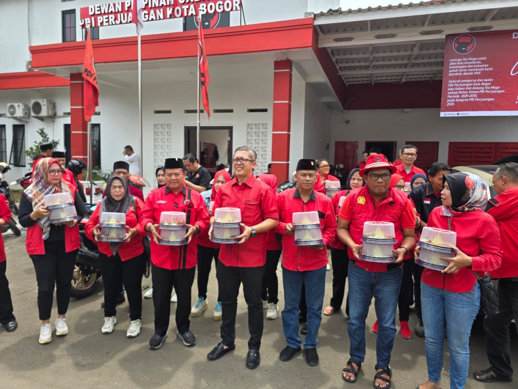 Ketua DPC PDI Perjuangan Kota Bogor, Dadang Iskandar Danubrata (tengah) bersama kader saat membagikan nasi tumpeng.