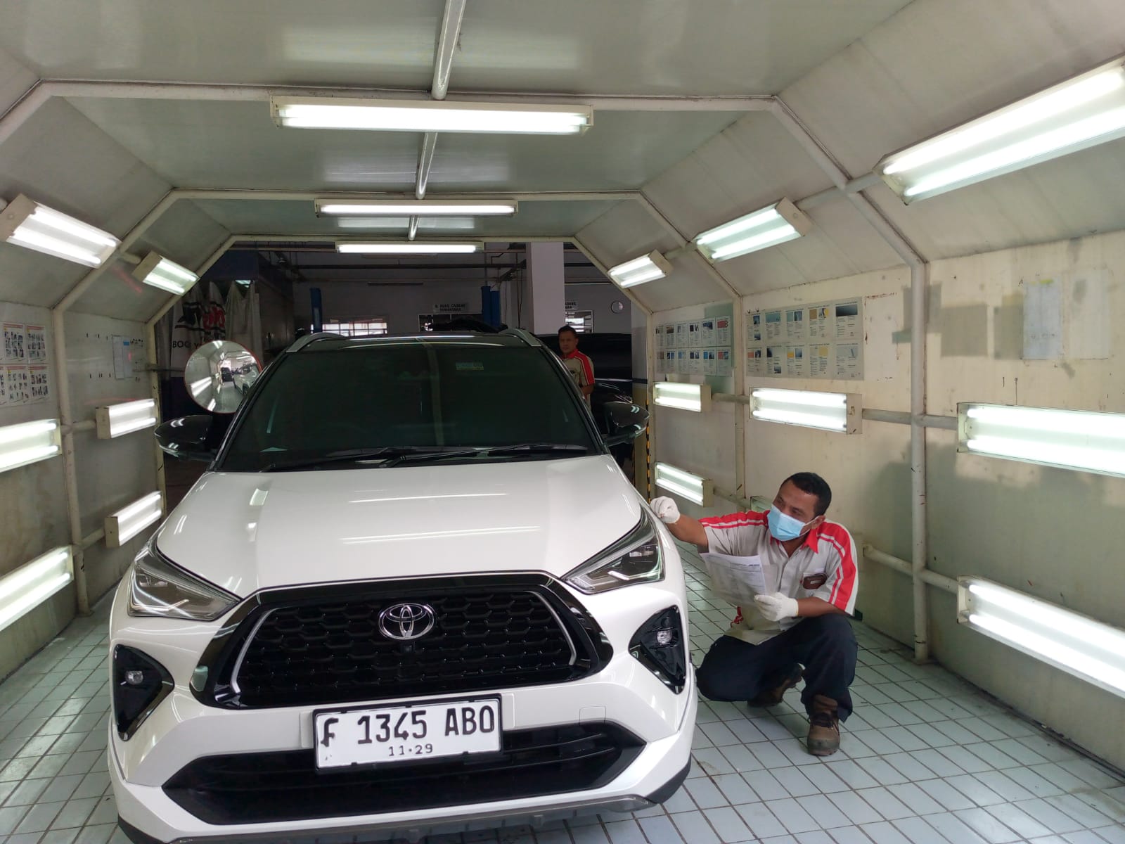 Petugas Auto2000 Bogor Yasmin membersihkan jamur kaca mobil.