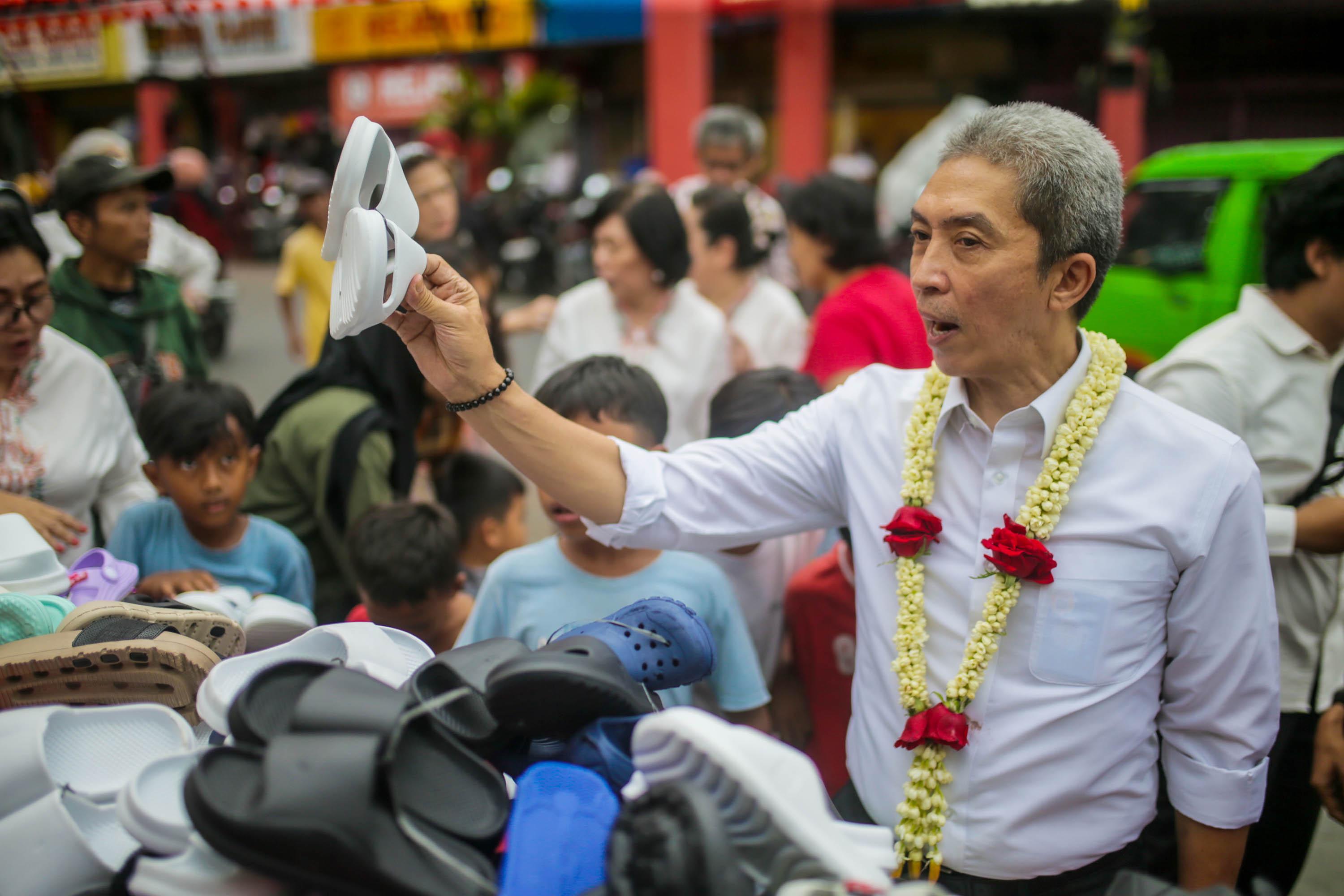 Dedie Rachim saat memborong sandal untuk dibagikan kepada anak-anak yang datang dan mengikutinya di Bazar Rakyat CGM.