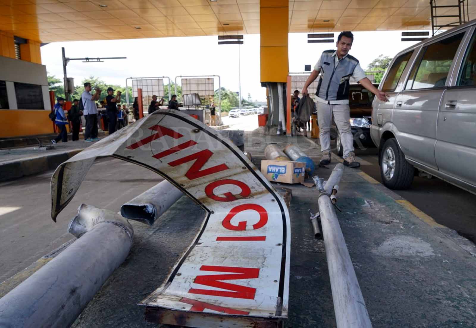 Petugas bersihkan sisa puing gerbang Tol Ciawi Bogor pasca kecelakaan maut. Foto :