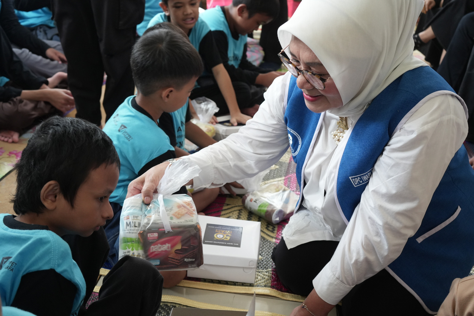 Pembagian makan bergizi gratis kepada anak-anak oleh IWAPI Kabupaten Bogor.