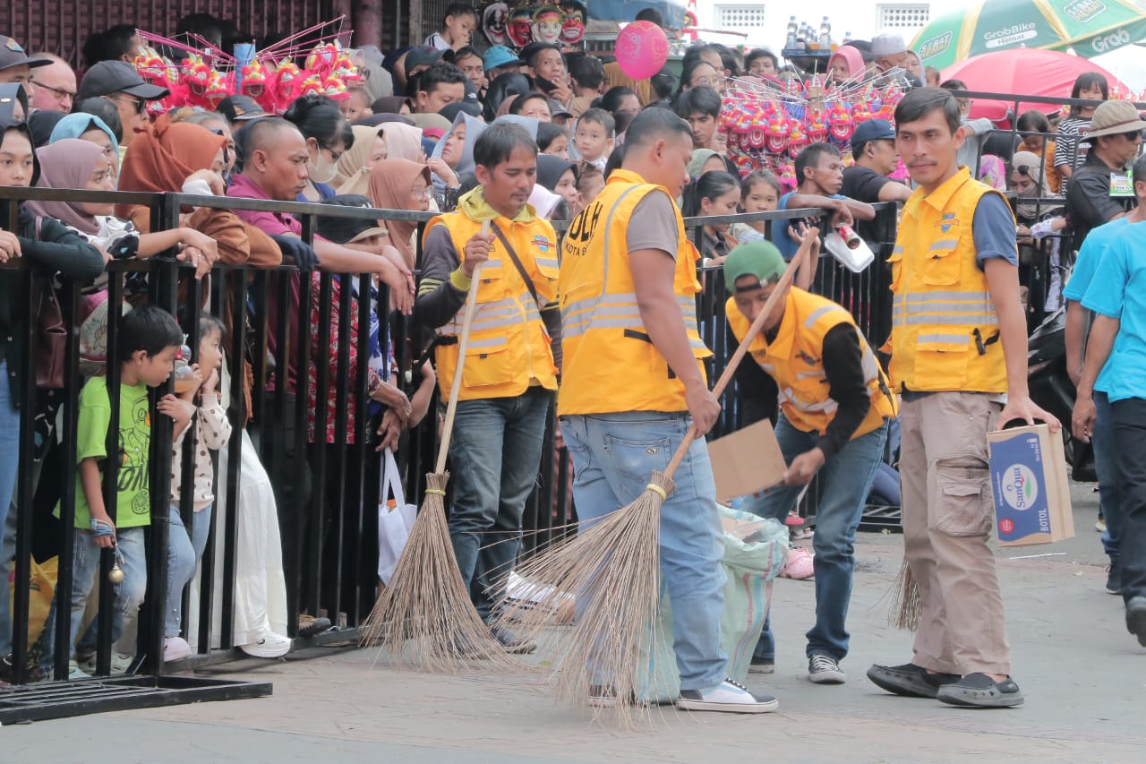 Pasukan kuning tengah membersihkan sampah di area helaran Bogor Street Festival Cap Go Meh.