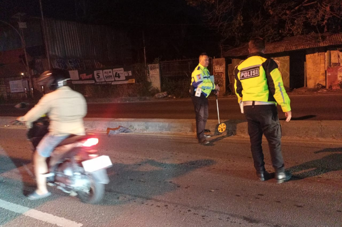 Polisi saat melakukan olah TKP di lokasi kecelakaan motor listrik dan truk di Jalan Raya Parung Bogor.