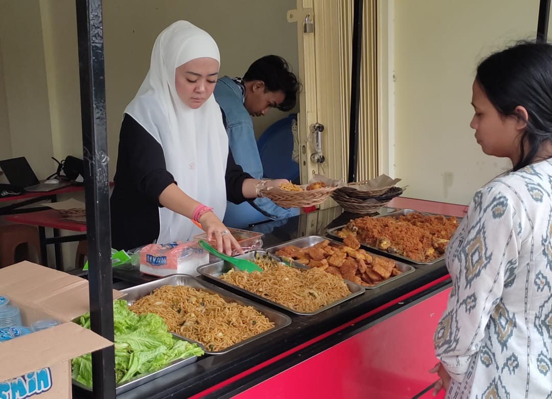 Owner Rumah Makan Gratis Noni Ayi tengah melayani pelanggannya.