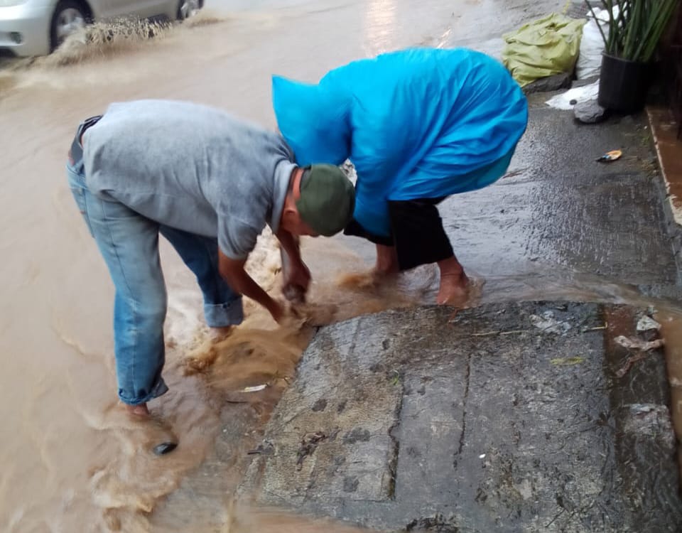 Warga gotong royong membersihkan saluran drainase di Jalan Raya Puncak, Gadog Bogor yang sebabkan banjir.