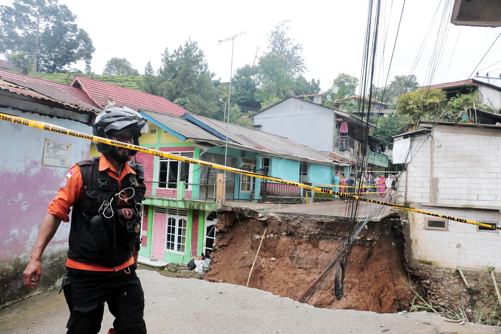 Petugas berada di jembatan terputus akibat banjir bandang di Kampung Pensiunan, Cisarua. Foto :