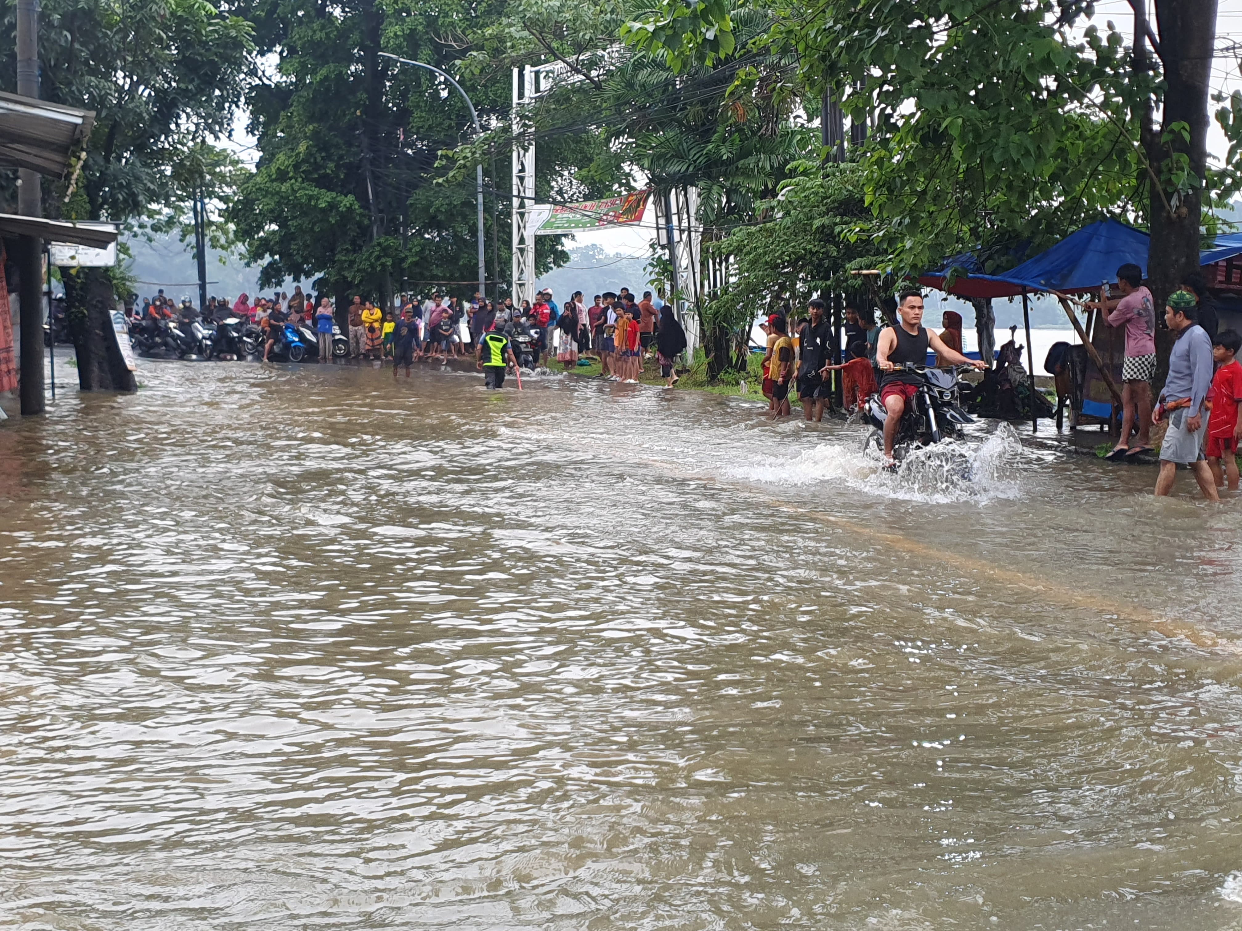 Kendaraan melintas di Jalan Lingkar Setu Cikaret - Cibinong Bogor yang terendam, Selasa (4/3/2025).
