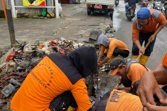 Proses pengerjaan drainase yang tersumbat di Jalan Kapten Yusuf Cikaret, Kecamatan Bogor Selatan, Kota Bogor.