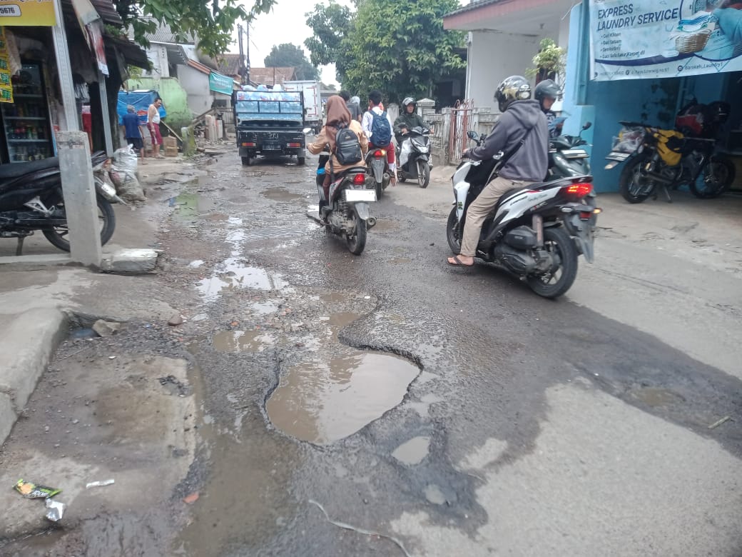Kondisi Jalan Raya Ciherang yag berlubang membahayakan para pengendara motor.
