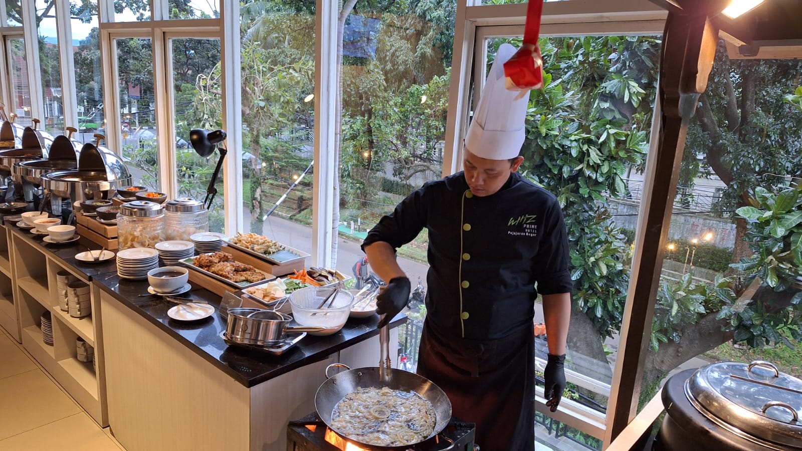 Salah satu chef Whiz Prime Hotel Pajajaran Bogor tengah menghidangkan kudapan makanan.