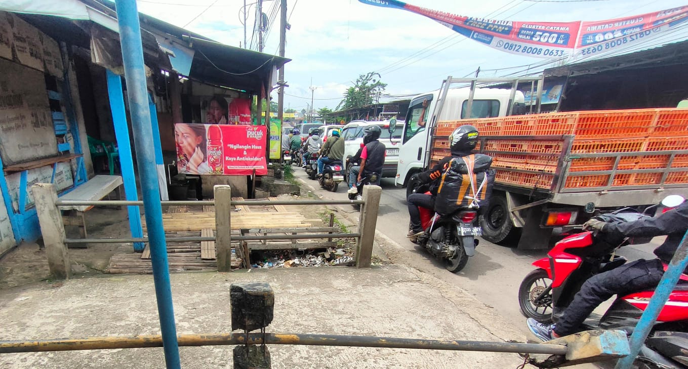 Penampakan bangunan liar yang berdiri di atas saluran air di Jalan Raya Kemang  - Parung