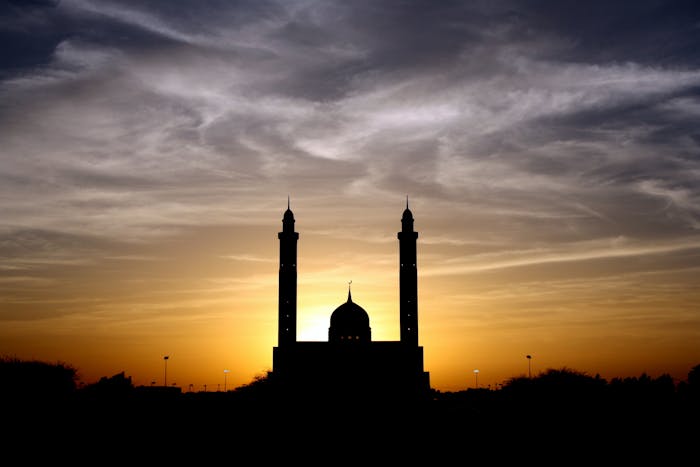 Siluet masjid saat matahari terbenam.