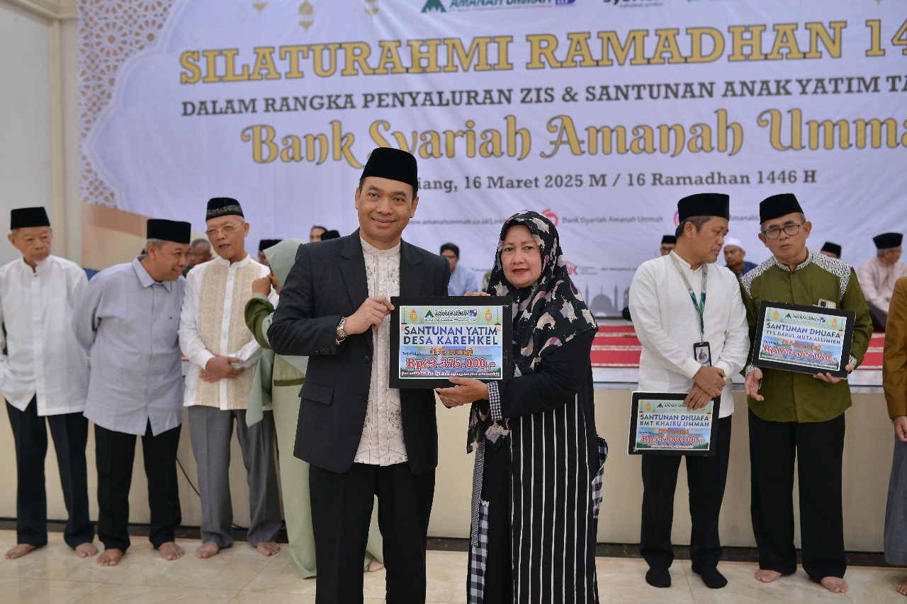 Direktur Utama Bank Syariah Amanah Ummah, Hendi Sofyan menyerahkan ZIS kepada penerima manfaat.