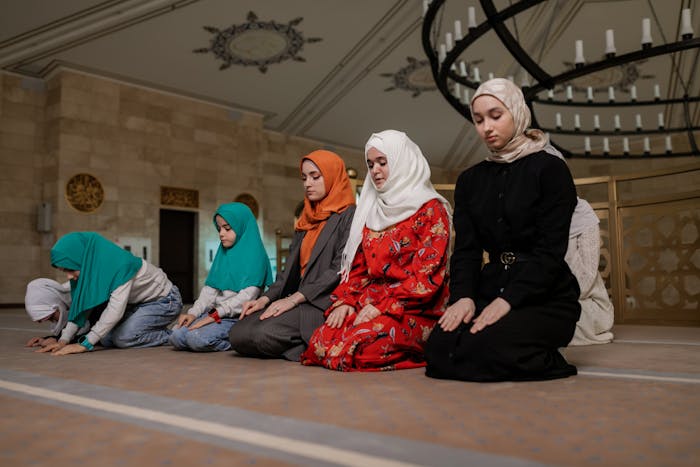 Sekelompok perempuan berhijab sedang salat di Masjid.
